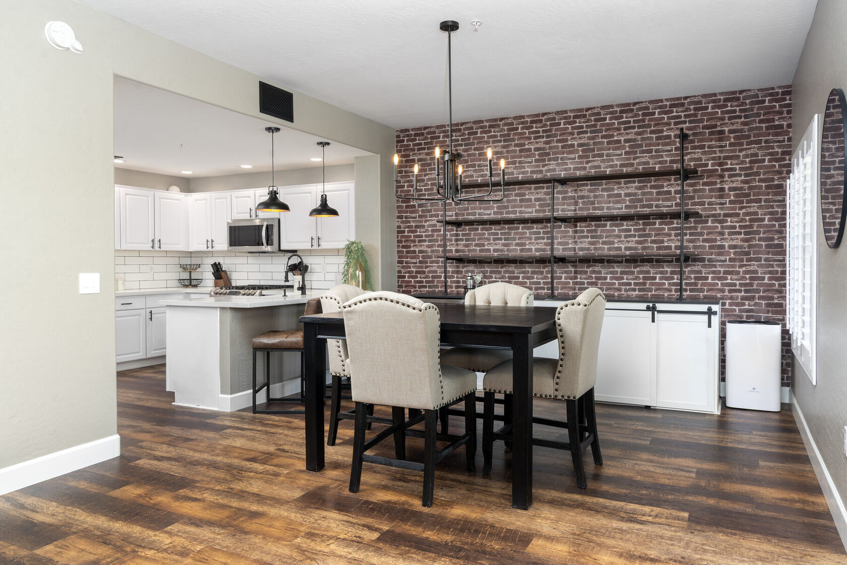 Dining area with brick accent wall and open shelving