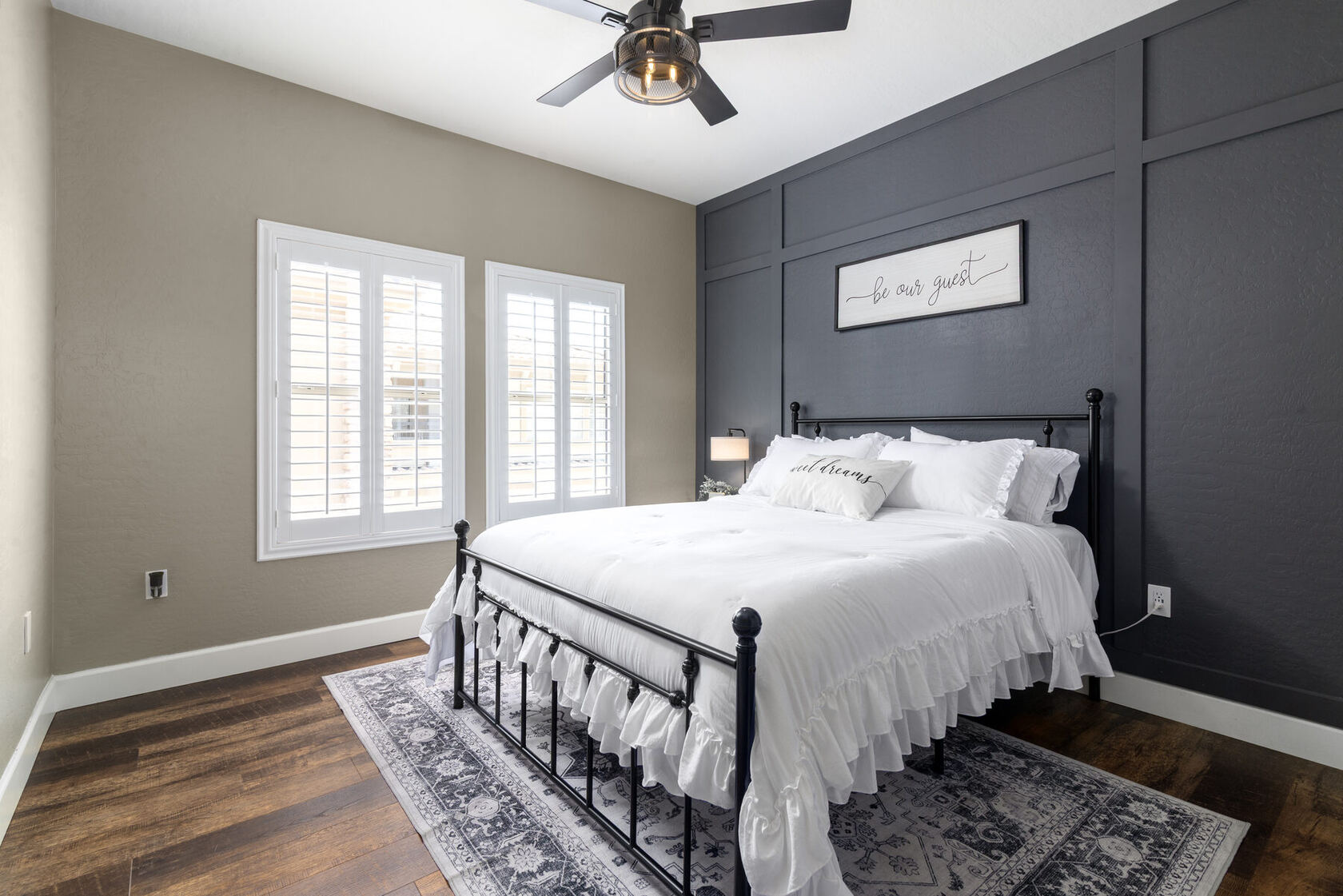 Guest bedroom with queen bed and dark accent wall
